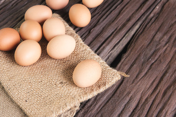  raw chicken eggs in egg box on old brown wooden
