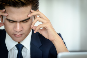 Businessmen dressed smart are using the idea of hard work and headaches. Sit with a laptop computer in the office. Business and Technology Concepts.