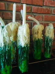 green candles in bottles with wine