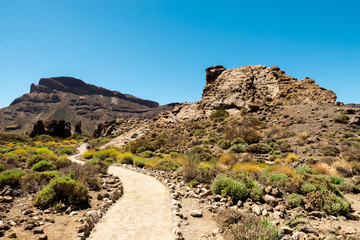 View of landscape of Teide National Park on Tenerife, Canarias islands, Spain. Yellow and black sand and distance view of mountains roads and volcano.