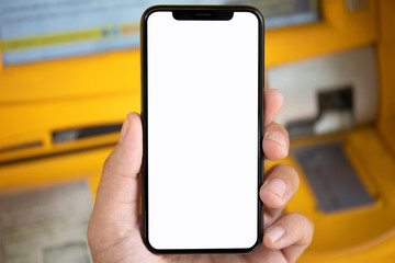 man hand holding phone with isolated screen on yellow ATM