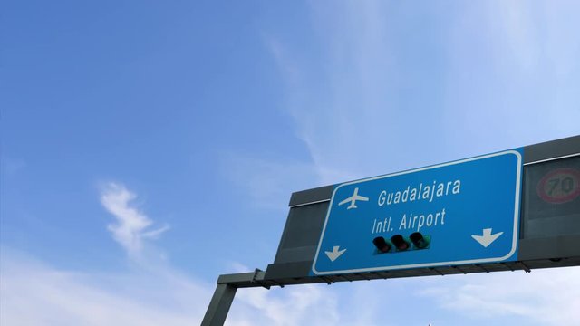 airplane flying over guadalajara airport signboard