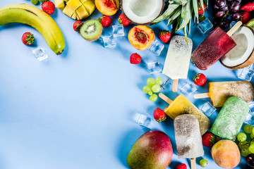 Tropical ice cream popsicles with chia seeds and fruit juices - pineapple, orange, mango, banana, kiwi, coconut, grapes, peach, strawberry, copy space