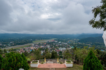 Fototapeta na wymiar Runway of Airport in Countryside with village and lake in the hill in the cloudy day with soft sunlight, Traveling in Thailand