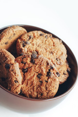 Chocolate cookies in a brown bowl on a white background