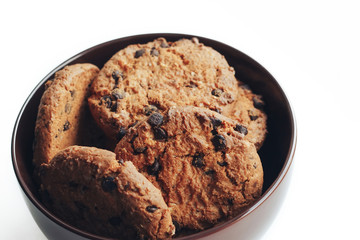 Chocolate cookies in a brown bowl on a white background