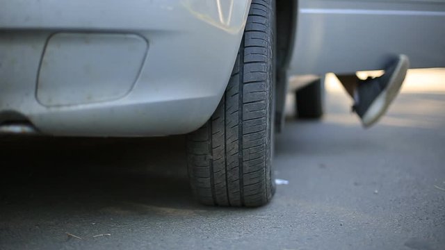 a man sits in the car turns the steering wheel, turn the wheels.