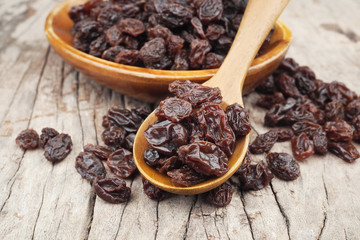 Organic dried Raisins in wood spoon on wooden table, Currant