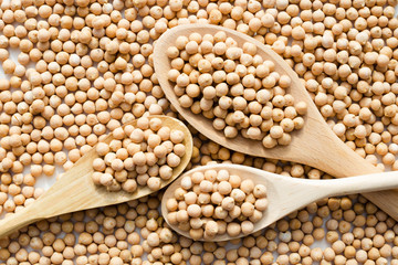 Fototapeta premium dry raw chickpeas in wooden spoons