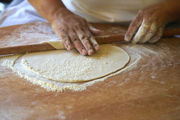 Turkish woman rolling dough  - obrazy, fototapety, plakaty