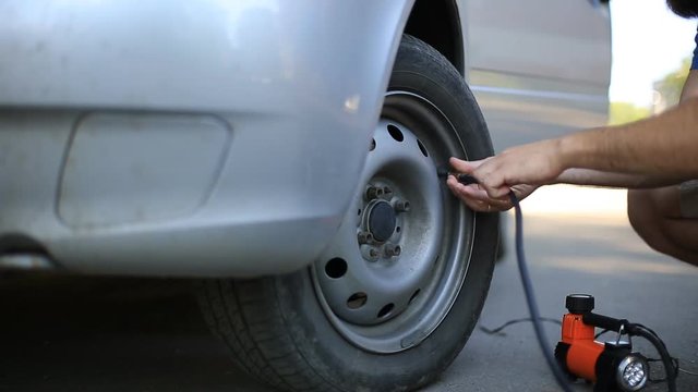 man compressor pump pumps the front wheel of the car.