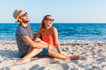 Fototapeta premium Young couple in love lying on the beach enjoying