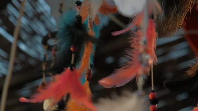 Colorful feathers and beads swing from dream catchers on Indian night market