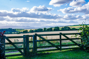 Fototapeta na wymiar Looking past a wooden fence at the Scottish landscape beyond