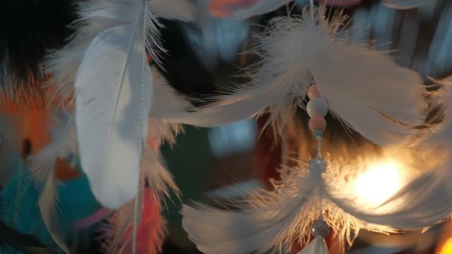 Colorful feathers and beads swing from dream catchers on Indian night market