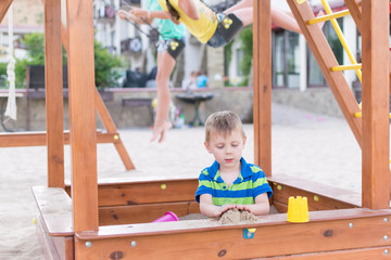 A little boy in the playground in the sandbox