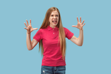 Fototapeta premium Portrait of an angry woman looking at camera isolated on a blue background