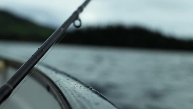 Close up of a fishing rod in a small boat during a clody day. Filmed in Canada during summer.