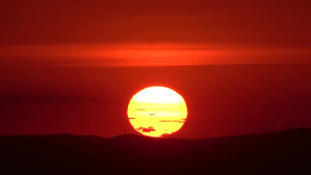 Flugzeug fliegt durch untergehende Sonne, Sonnenuntergang, Abendrot