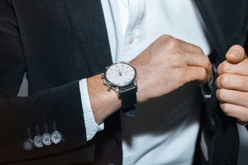 closeup fashion image of luxury watch on wrist of man.body detail of a business man.Man's hand in a...