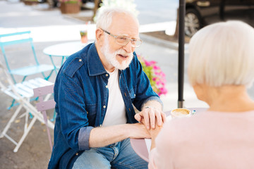 Obraz premium Interesting idea. Appealing senior man sitting with wife and talking