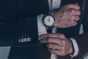 closeup fashion image of luxury watch on wrist of man.body detail of a business man.Man's hand in a grey shirt with cufflinks. Tonal correction  - Powered by Adobe