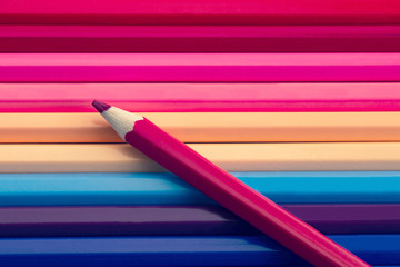 pink color pencil on many colorful pencils background, pastel colours tone.
