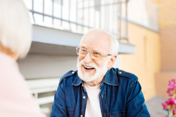 Pleasant conversation. Jovial senior man talking with wife and laughing