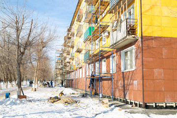 Fototapeta premium Warming of the apartment house. External repair work on the building, insulation and cladding of the facade of the house