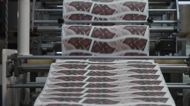 Machinery shop. Punching machine. Die cutting of paper or carton templates for disposable dishes production. Manufacturing from environmentally friendly recyclable materials. Moving parts of mechanism