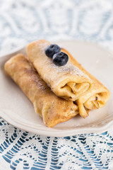 Three homemade rolled pancakes with blueberry