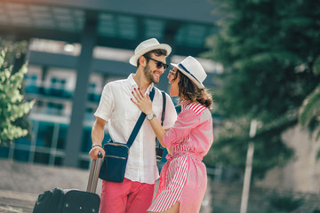 Smiling young travellers couple looking for hotel