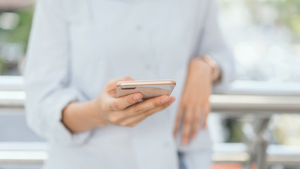 woman using smartphone on staircase in public areas, During leisure time. The concept of using the phone is essential in everyday life.