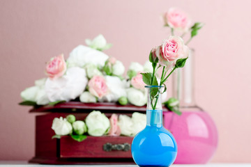 Flower arrangement with summer roses on a pink background