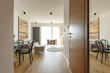 Wooden door in bright open space interior with chair and colorfu
