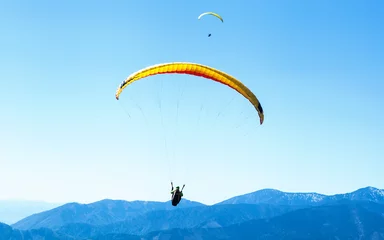 Crédence de cuisine en verre imprimé Sports aériens Deux parapentes planant dans le ciel au-dessus des montagnes bleues
