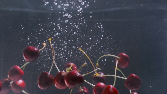 Cherry falls to the water slowly.Close up, Slow motion.