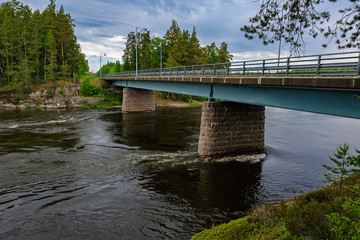 Automotive bridge over Kymijoki river at summer overcast day. Finland.