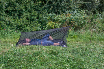 Mann liegt in Insektenschutz Zelt