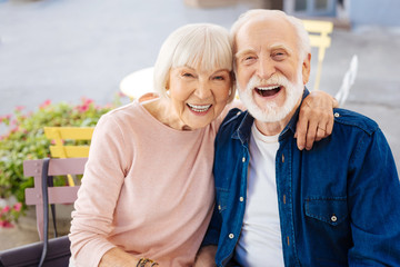 Young inside. Cheerful senior couple laughing and looking at camera