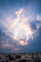 Heavenly Light Rays Piercing Through the Clouds over the Greek Sea .