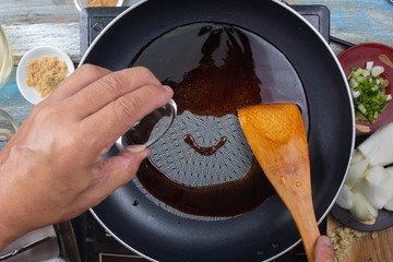 Chef poring mirin  to pan for cooking