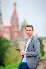 Happy young urban man drinking coffee in european city.