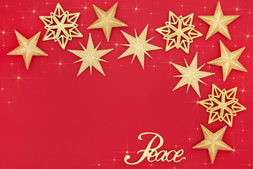 Christmas background with gold star bauble decorations and peace sign on red with copy space....