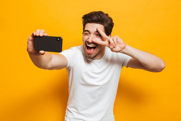 Portrait of a cheerful young man taking a sefie