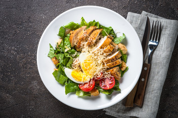 Caesar salad with chicken breast and tomatoes.