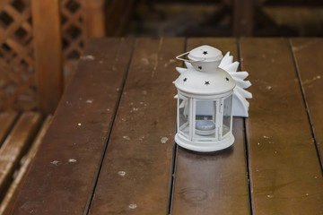 The old white lantern stands on a wooden table.