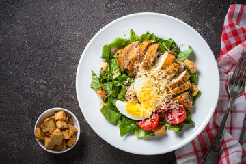 Caesar salad with chicken breast and tomatoes.