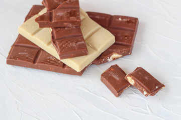 White and milk chocolate. Tiles of chocolate on a white background