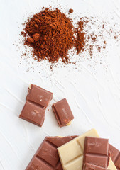 Coffee,white and milk chocolate. Tiles of chocolate on a white background.